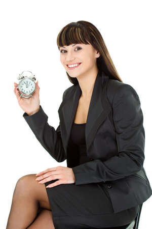 woman holding alarm sitting on chair over whiteの写真素材