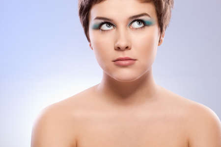 brunette woman portrait with blue makeup over whiteの写真素材