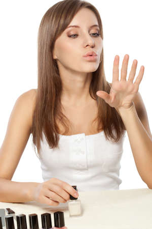 beautiful woman drying polished nails over whiteの写真素材