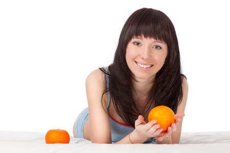 woman on bed beautiful holding orangeの写真素材