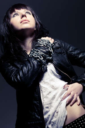 woman wearing leather jacket dark style portrait wityh chain on handの写真素材