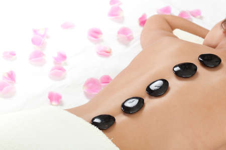 beautiful woman with spa stones on backの写真素材