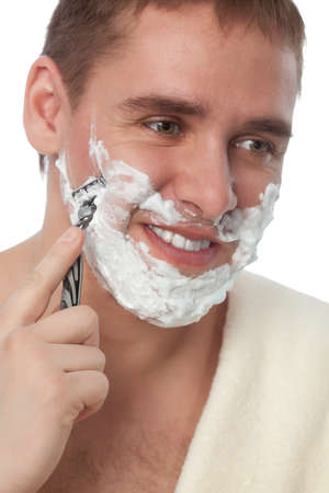 attractive man shaving his face over whiteの写真素材