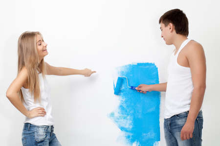 Portrait of happy young loving couple with paintbrushの写真素材