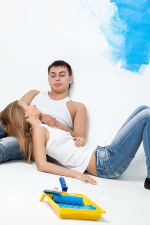 resting young loving couple with paintbrushesの写真素材