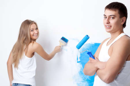 Portrait of happy young loving couple with paintbrushの写真素材