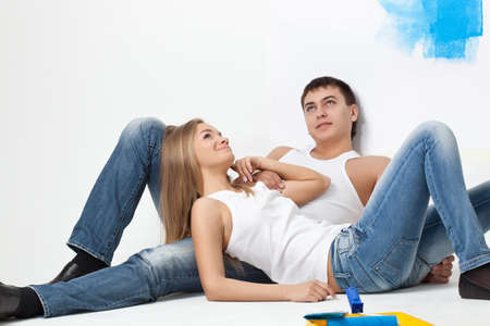 resting young loving couple with paintbrushesの写真素材