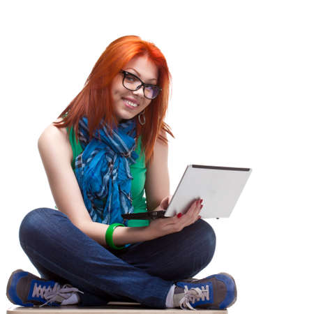 happy girl sitting with laptop over whiteの写真素材
