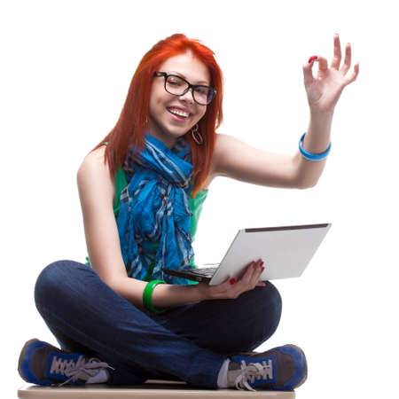 happy girl sitting with laptop over whiteの写真素材