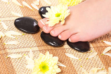 woman feet taking over spa treatment with stonesの写真素材