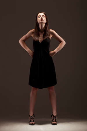 fashion model posing in studio, wearing black dressの写真素材