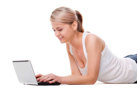 woman laying on the floor with laptop, studio shot over whiteの写真素材