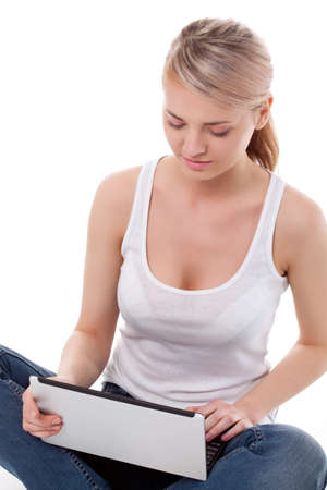 woman sitting on the floor with laptop, studio shot over whiteの写真素材