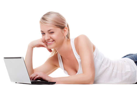 woman laying on the floor with laptop, studio shot over whiteの写真素材
