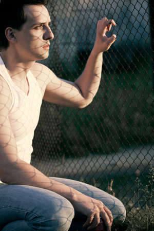 outdoor sitting near lattice man portraitの写真素材