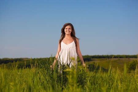 beautiful woman walking on green fieldの写真素材