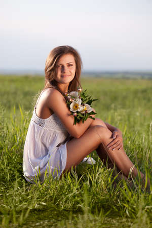 beautiful woman sitting on  green fieldの写真素材