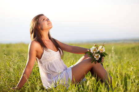 beautiful woman sitting on  green fieldの写真素材