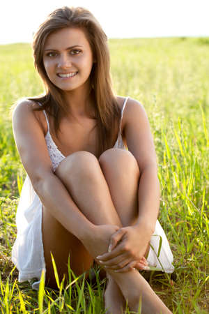 beautiful woman sitting on  green fieldの写真素材
