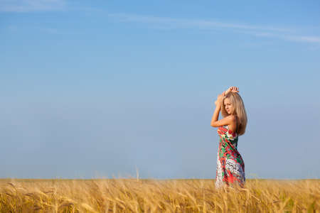 beautiful woman walking on wheat fieldの写真素材