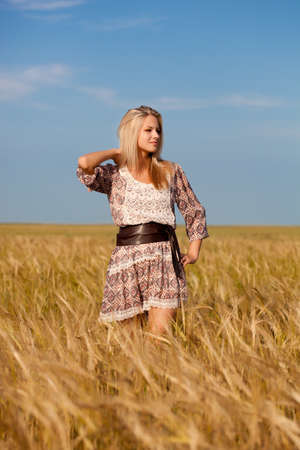 beautiful woman walking on wheat fieldの写真素材