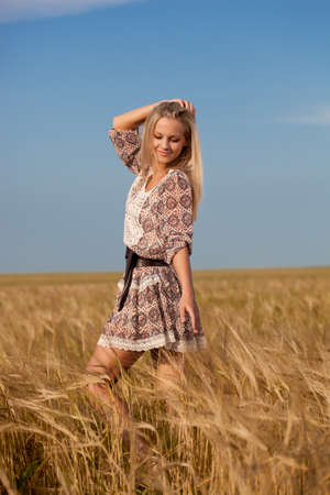 beautiful woman walking on wheat fieldの写真素材
