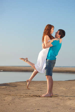 young adult happy couple walking on beachの写真素材