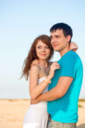 young adult happy couple embracing on beachの写真素材