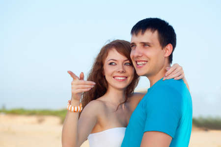 young adult happy couple embracing on beachの写真素材