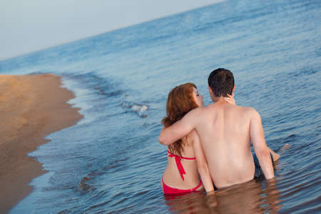 young adult happy couple couple sitting in waterの写真素材