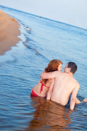 young adult happy couple couple sitting in waterの写真素材