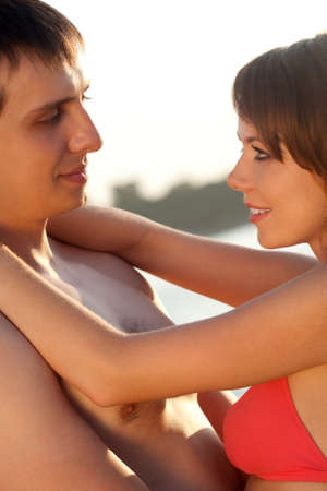 young adult happy couple embracing on beachの写真素材