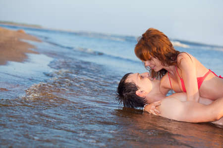 young adult happy couple couple laying waterの写真素材
