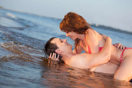 young adult happy couple couple laying waterの写真素材