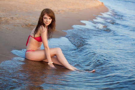 beautiful red-haired  woman wearing bikini on beachの写真素材