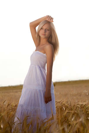 beautiful woman walking on wheat fieldの写真素材