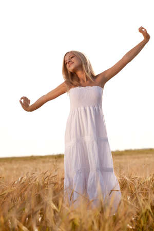beautiful woman walking on wheat fieldの写真素材