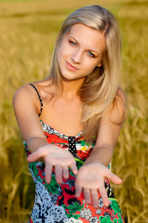 beautiful woman walking on wheat fieldの写真素材