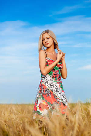 beautiful woman walking on wheat fieldの写真素材