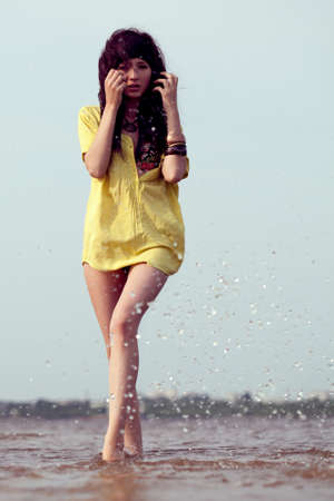 beautiful fashion model woman walking on waterの写真素材