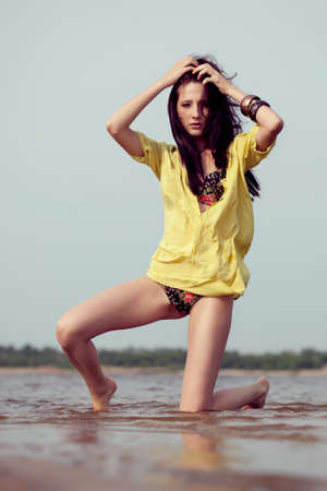 beautiful fashion model woman walking on waterの写真素材