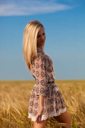 beautiful woman walking on wheat fieldの写真素材