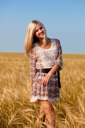 beautiful woman walking on wheat fieldの写真素材