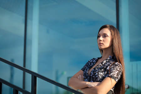 seriously brunette woman standing on  over glass wall background