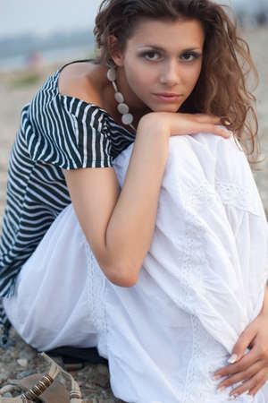 beautiful brunette   woman portrait sitting on coast, closeupの写真素材