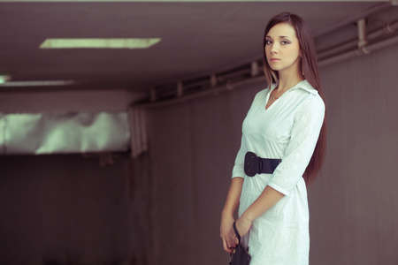 beautiful brunette woman standing with clutchの写真素材