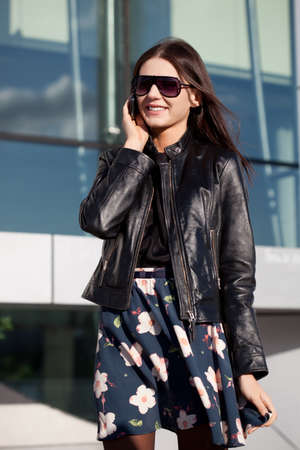woman wearing sunglasses talking by phone outdoorsの写真素材