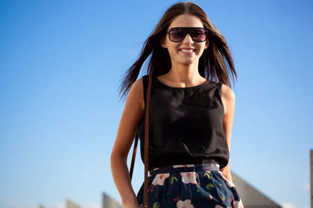 smiling woman wearing sunglasses  over blue skyの写真素材