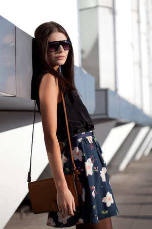woman wearing sunglasses with leather brown bagの写真素材
