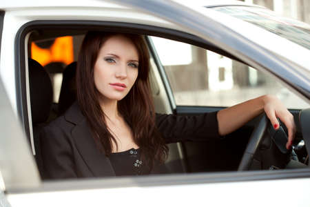 woman sitting in white car, looking trough windowの写真素材